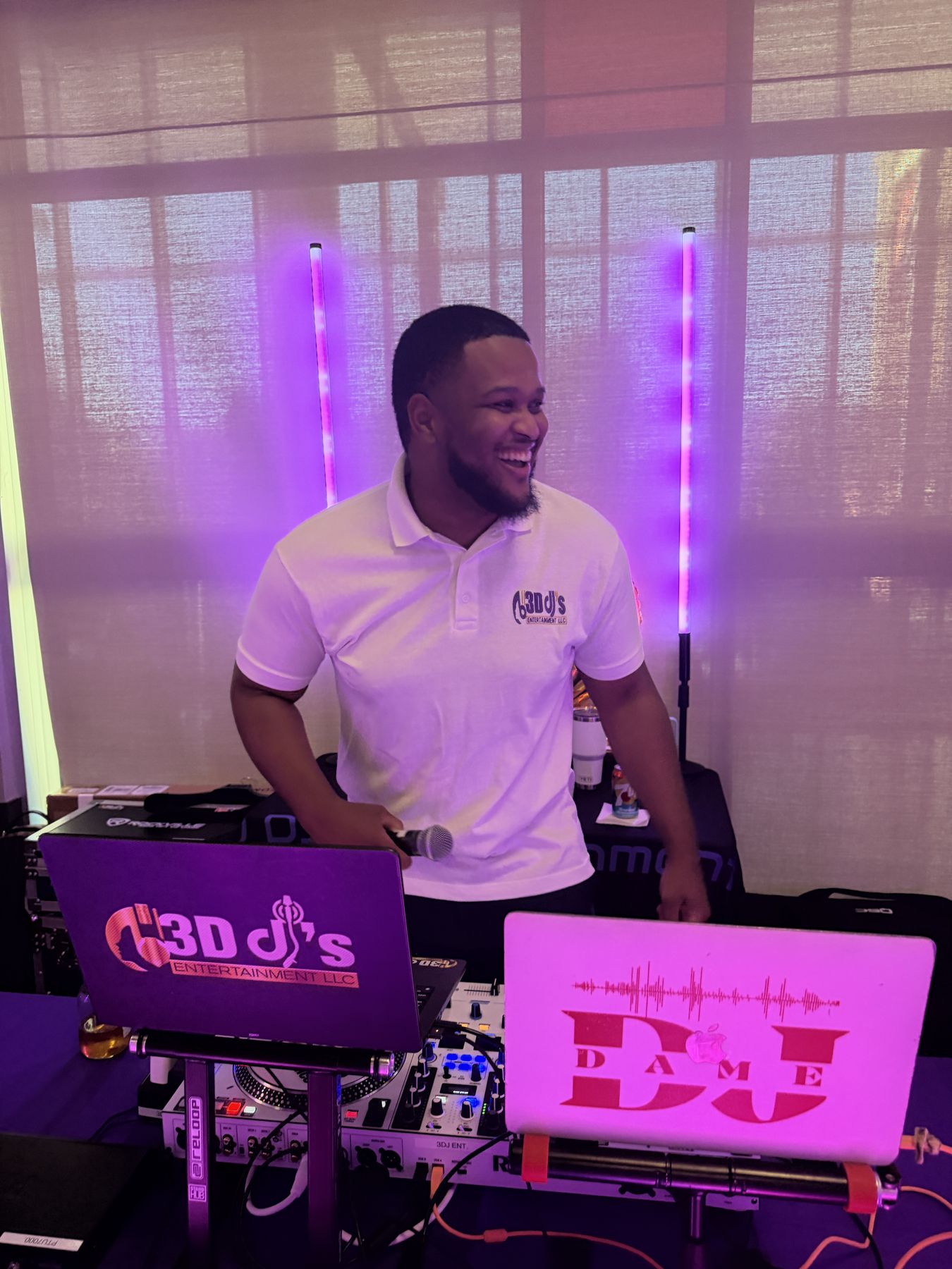 DJ laughing at the decks behind 3D DJ's and DJ Dame laptops
